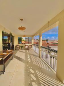 Zimmer mit einem Balkon mit Tisch und Stühlen in der Unterkunft Lar dos Lençóis in Barreirinhas