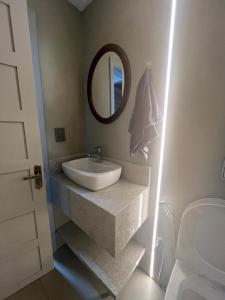 un baño con lavabo y espejo en Garibaldi Guest House, en Boa Vista 15 fotos más