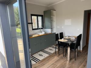 eine Küche und ein Esszimmer mit Tisch und Stühlen in der Unterkunft Casa Rosa in Porto da Cruz + 21 Fotos