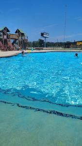 una grande piscina di acqua blu con persone all'interno di Bryan North College Station KOA Holiday a Bryan
