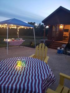 un tavolo con sedie e un ombrellone in un cortile di Bryan North College Station KOA Holiday a Bryan