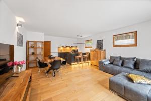 ein Wohnzimmer mit Sofa und Tisch in der Unterkunft Moderne Ferienwohnung mit Bergblick und großer Terrasse nahe Simssee, Chiemsee und Autobahn A8 Salzburg - München in Rohrdorf