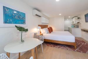 a small bedroom with a bed and a table and a dining room at THE JUNI Studio Surf Paradise in Heart of Cocoa Beach in Cocoa Beach