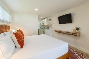 a bedroom with a white bed and a flat screen tv at THE JUNI Studio Surf Paradise in Heart of Cocoa Beach in Cocoa Beach +26 photos