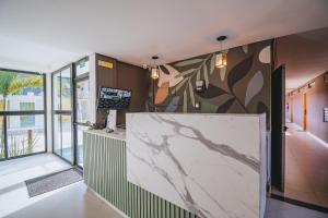 a lobby with a marble counter and a large window at Condomínio encantador com piscina in Ipojuca