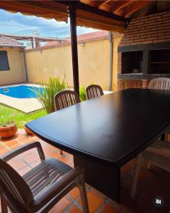 einen schwarzen Tisch und Stühle auf einer Terrasse mit einem Pool in der Unterkunft La Emilia Casa de Vacaciones con Pileta y Quincho in Salta + 26 Fotos