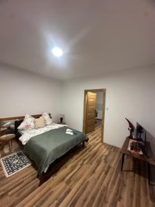 a bedroom with a bed and a wooden floor at Świecie Apartament Biznesowy in Świecie