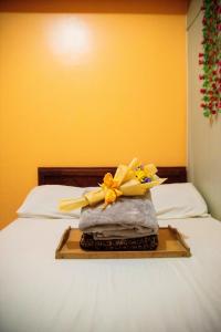 a tray with flowers on top of a bed at Wind Residences For Rent - Luiice in Tagaytay