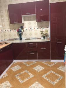 una cucina con armadietti viola e pavimenti in legno di Luxurious Chantan Apartment a Chantan Altre 2 foto