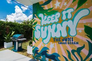 a wall with a sign that says keep up surfing at THE JUNI - Studio Steps to Beach Downtown Cocoa in Cocoa Beach
