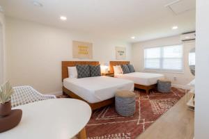 a bedroom with two beds and a couch at THE JUNI - Studio Steps to Beach Downtown Cocoa in Cocoa Beach