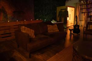 a living room with a brown couch and a guitar at Loft avec Spa Privatif in Frameries