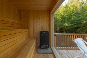 a cabin with a heater on a wooden deck at Maison Solus - Mont Tremblant in Lac-Superieur