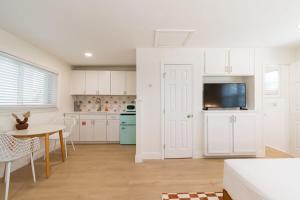a kitchen with white cabinets and a table and a dining room at THE JUNI - Studio Steps to Beach Downtown in Cocoa Beach +22 photos