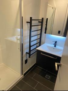 mała łazienka z umywalką i prysznicem w obiekcie City life Skytower view With Swimming pools & Suna Family Retreat w Auckland