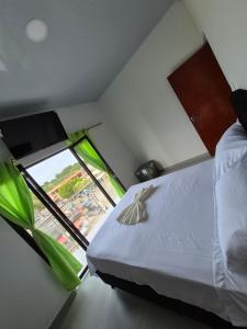 una camera da letto con un letto e una grande finestra di APARTAHOTEL PUERTA DEl MAR a Necoclí