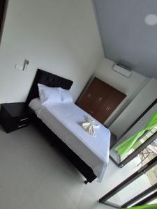 una camera da letto con un letto con un piumone bianco di APARTAHOTEL PUERTA DEl MAR a Necoclí