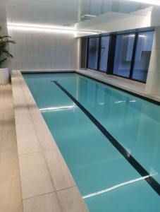 a swimming pool with blue water in a building at VC Skytower view With Swimming pools & Suna Family Retreat in Auckland