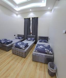 3 posti letto in una camera con pavimenti in legno di Algharam resort a Ḩaḑīb