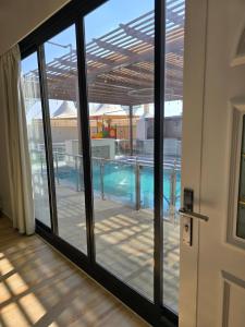 vista sulla piscina attraverso una porta scorrevole in vetro di Algharam resort a Ḩaḑīb Altre 6 foto
