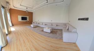 una grande stanza con divani bianchi e una TV di Algharam resort a Ḩaḑīb