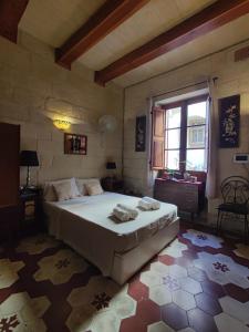 Un dormitorio con una cama grande y una ventana. en The Little Duke Residence, en Hamrun