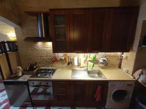 Una pequeña cocina con estufa y fregadero. en The Little Duke Residence, en Hamrun 5 fotos más