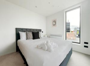 białe łóżko z pluszakiem na górze w obiekcie City life Skytower view With Swimming pools & Suna Family Retreat w Auckland +22 zdjęcia