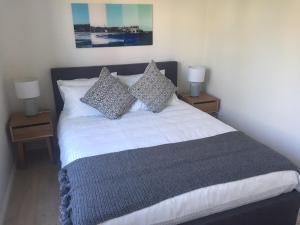 a bedroom with a bed with pillows and two lamps at Hoffy's Place - Modern one bedroom with AC in Sydney