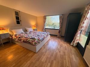 una camera da letto con un letto e una grande finestra di Charming house surrounded by nature a Courtonne-la-Meurdrac