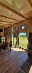 库拉考廷Cabaña 4 Acogedora en un entorno natural的带桌子和大窗户的餐厅