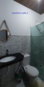a bathroom with a toilet and a sink and a mirror at Falésias de Carapibus - Casa de temporada 06 - Jacumã in Conde