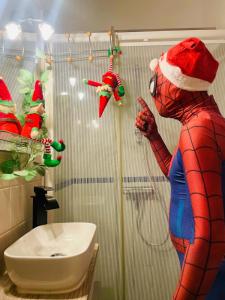 una persona in costume da Spider-Man in piedi sotto la doccia di Le repaire des héros 150m plage parking privé - lesvoyagescolorés a Saint-Valéry-en-Caux