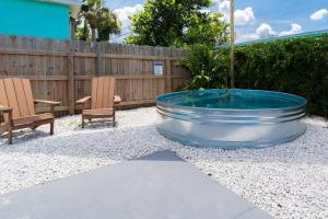 a pool in a backyard with two chairs and a fence at The Juni-7 Unit Renovated Complex in Cocoa Beach