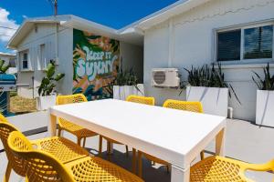 a white table and chairs in front of a building at The Juni-7 Unit Renovated Complex in Cocoa Beach