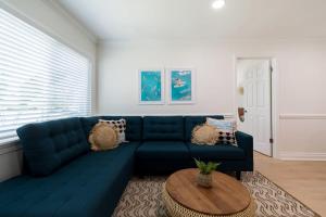 a living room with a blue couch and a table at The Juni-7 Unit Renovated Complex in Cocoa Beach +107 photos