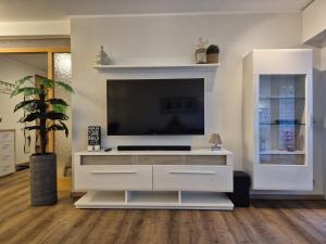 a large white entertainment center with a flat screen tv at Uni- und Citynahe Souterrain-Wohnung am Waldpark in Wuppertal