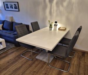 a white table with chairs and a blue couch at Uni- und Citynahe Souterrain-Wohnung am Waldpark in Wuppertal