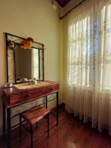 bagno con tavolo da trucco, specchio e finestra di Gouvas stone house a Karpenision Altre 25 foto