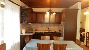 a kitchen with a table with chairs and a refrigerator at Gouvas stone house in Karpenisi +26 photos