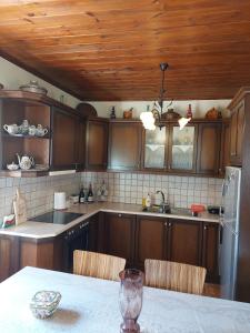 una cucina con mobili in legno e un tavolo con sedie di Gouvas stone house a Karpenision