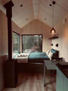 ein Schlafzimmer mit einem Bett in einem Zimmer mit einem Fenster in der Unterkunft TogetherNest - Cedar in Mătişeşti + 6 Fotos