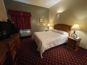 um quarto com uma cama, duas lâmpadas e uma janela em Northern Greens Resort and Conference Centre em Nipawin