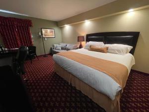 um quarto de hotel com uma cama grande e um sofá em Northern Greens Resort and Conference Centre em Nipawin mais 20 fotografias