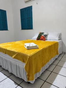 ein Bett mit einer gelben Decke darüber in der Unterkunft Villa Broadway Canoa Quebrada in Aracati