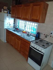 una cocina con estufa y refrigerador en Cabañas Los 3 Hermanos, en Tanti 8 fotos más