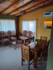 Una sala de estar con una mesa y sillas de madera. en Cabañas Los 3 Hermanos, en Tanti