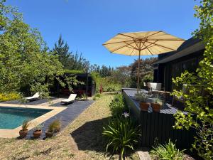patio con ombrellone e piscina di Casa Lodge Campo La Tranquilidad a El Convento