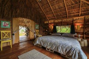 una camera con letto e TV a grande schermo di Glamping Hotel Flor y Bambu a Playa Grande