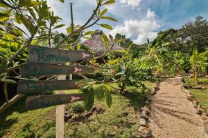 a sign for a banana plantation with a dirt road at Flor y Bambu in Playa Grande